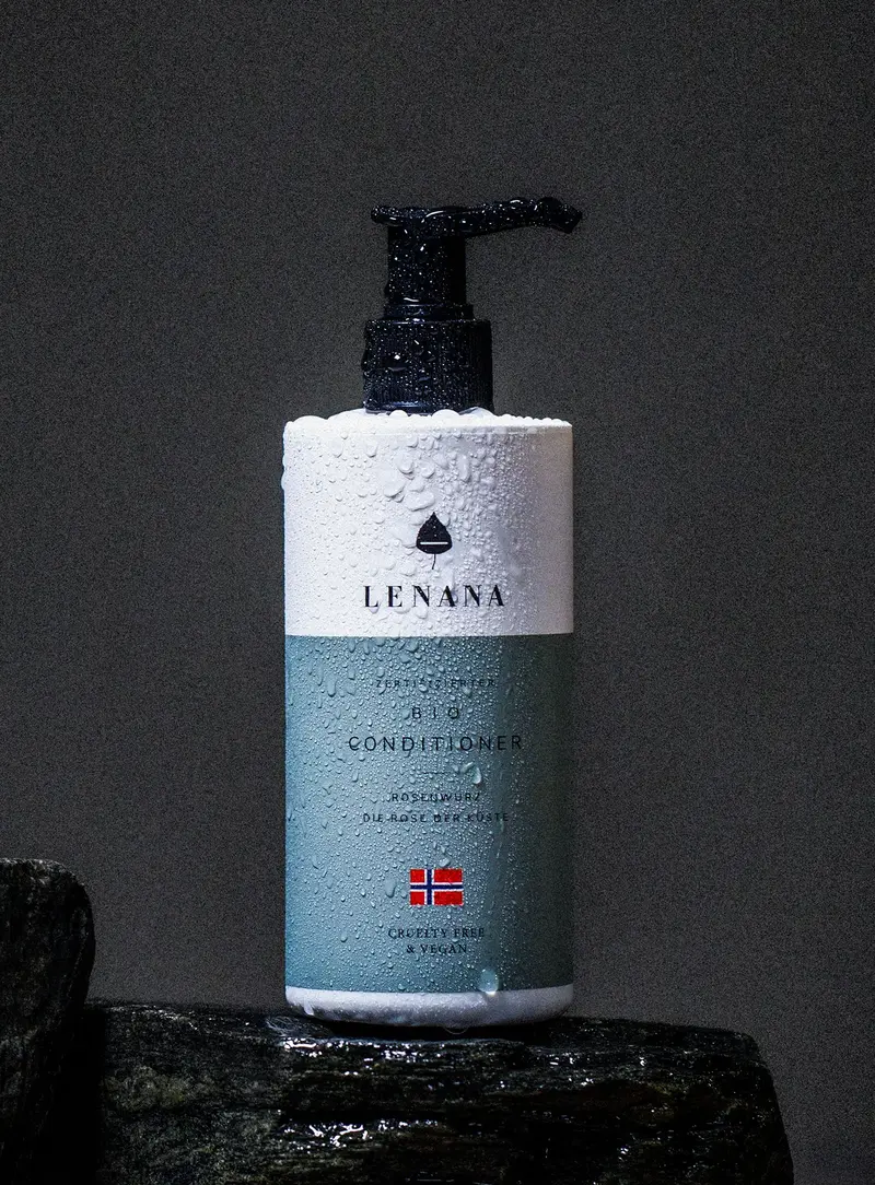 Conditioner Flasche ist blau Farbe mit norwegischen Flagge und und cruelty free &amp; vegan Label. Die Flasche ist in Wassertropfen und steht auf einem dunklen Stein
